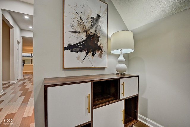 details with hardwood / wood-style flooring and a textured ceiling