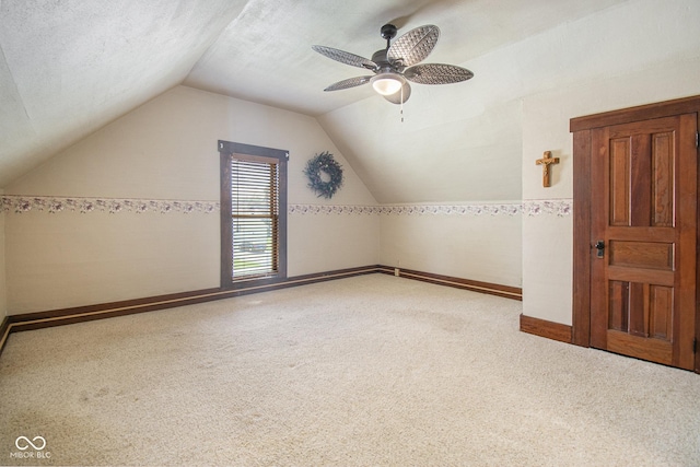 bonus room featuring ceiling fan, lofted ceiling, carpet, and a textured ceiling