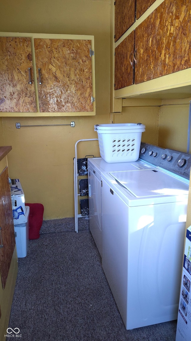 clothes washing area with cabinets, washing machine and dryer, and dark carpet