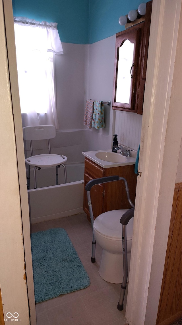 bathroom with vanity, tile patterned flooring, a bathing tub, and toilet