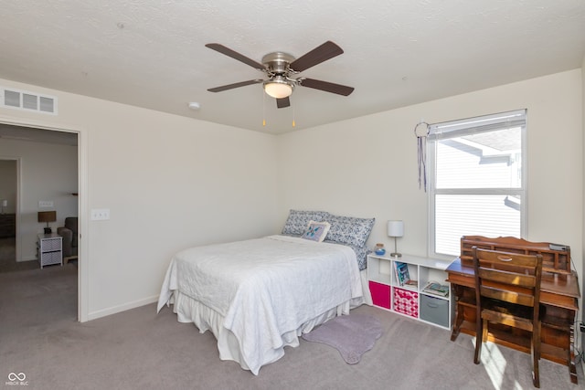 carpeted bedroom with a textured ceiling and ceiling fan