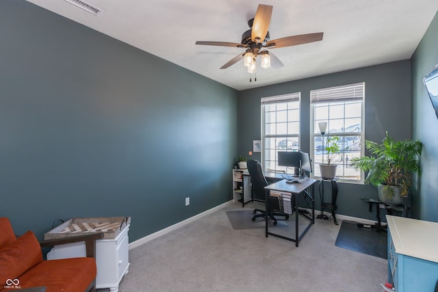 carpeted office space featuring ceiling fan