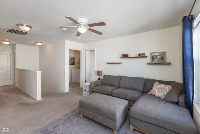 carpeted living room with ceiling fan