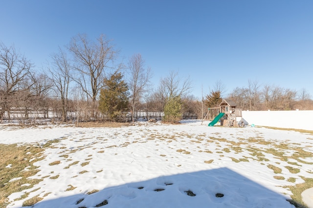 yard covered in snow with a playground