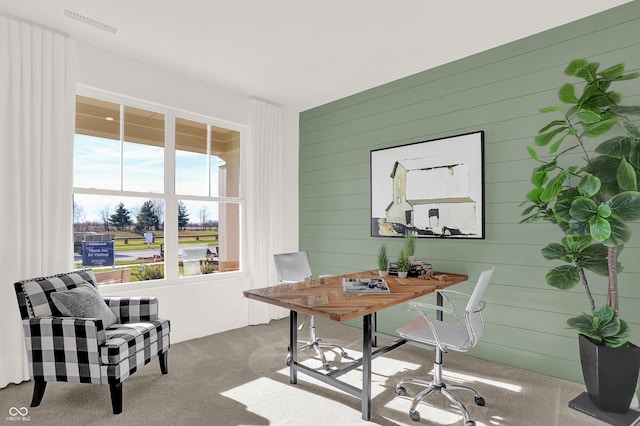 carpeted office space featuring wooden walls