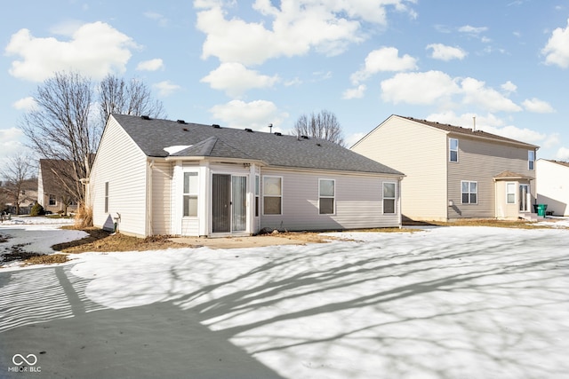 view of snow covered rear of property