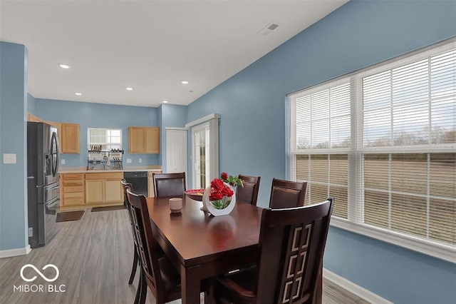 dining area with light wood-type flooring and sink