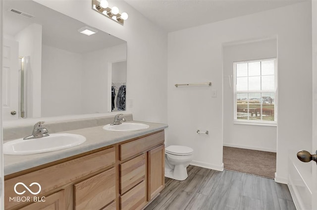 bathroom with hardwood / wood-style floors, toilet, and vanity