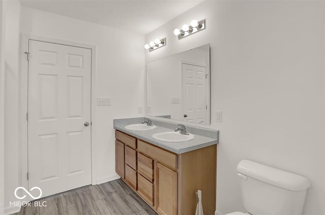 bathroom featuring hardwood / wood-style flooring, toilet, and vanity