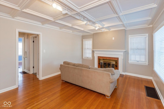 living room with a brick fireplace, wood-type flooring, and coffered ceiling