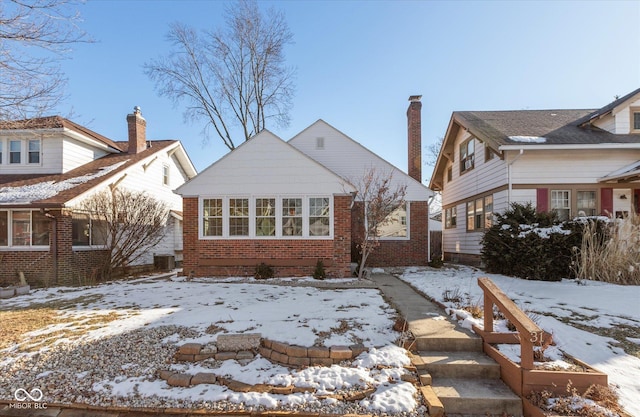 snow covered back of property featuring central AC