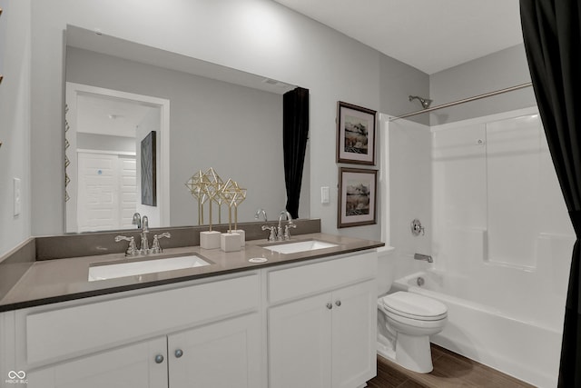 full bathroom featuring shower / washtub combination, wood-type flooring, vanity, and toilet