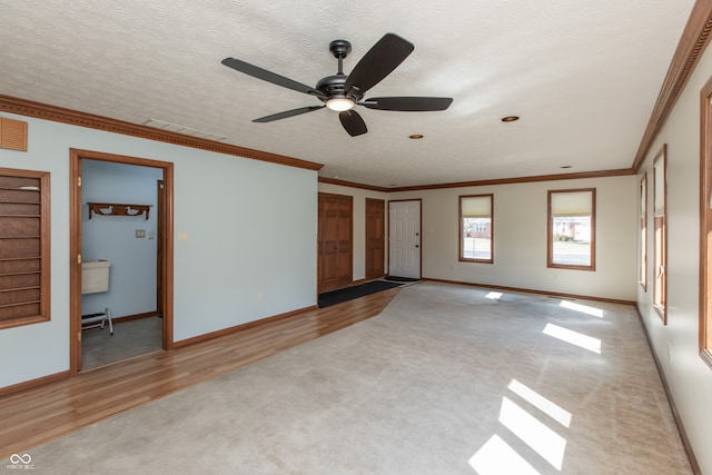 unfurnished living room with crown molding, carpet, visible vents, and a textured ceiling