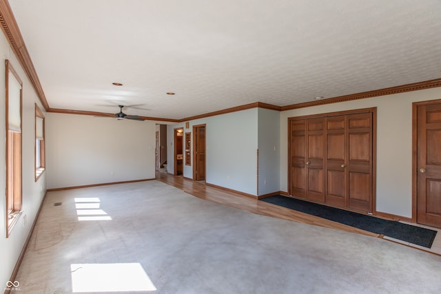 interior space featuring baseboards, light colored carpet, and ornamental molding