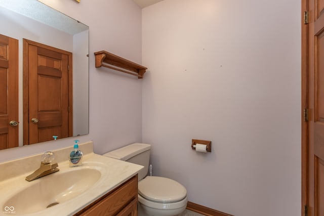 half bath featuring toilet and vanity