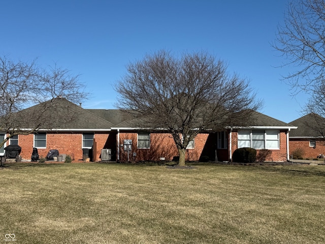 view of front of home with brick siding and a front yard