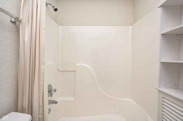 bathroom with shower / bath combo and toilet