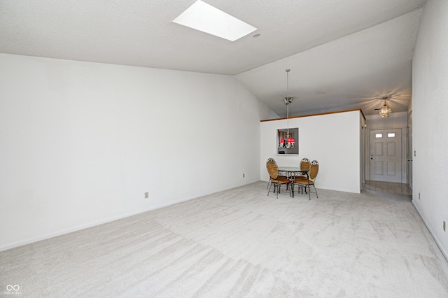 carpeted spare room with a textured ceiling and vaulted ceiling with skylight