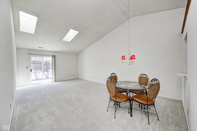 carpeted dining area with lofted ceiling with skylight and a textured ceiling