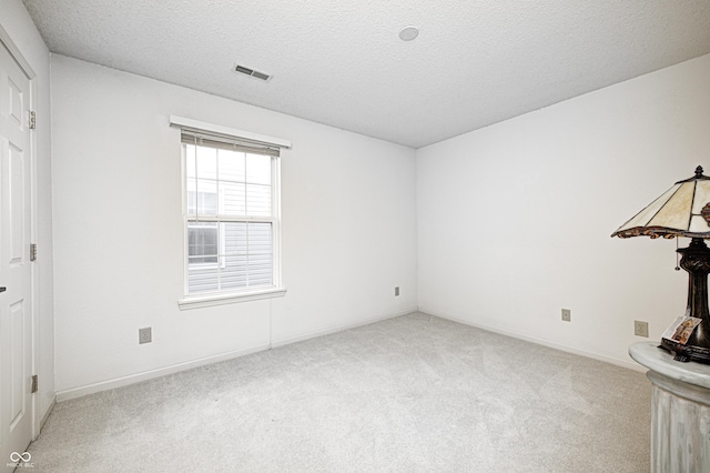 carpeted spare room with a textured ceiling