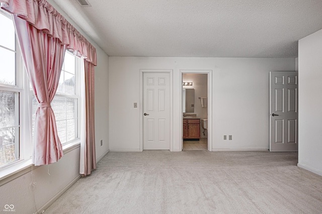 spare room with light colored carpet and a textured ceiling