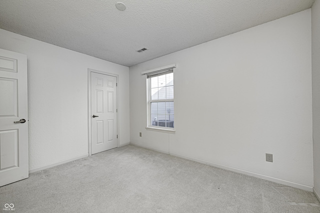 carpeted empty room with a textured ceiling