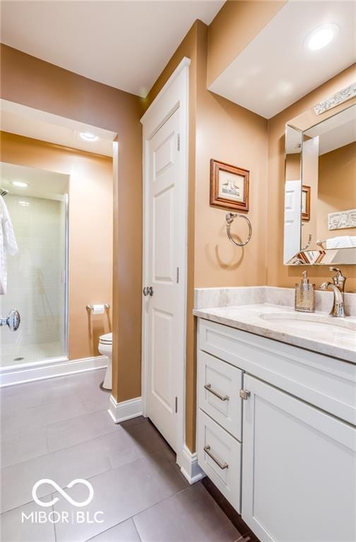 bathroom featuring vanity, toilet, an enclosed shower, and tile patterned flooring