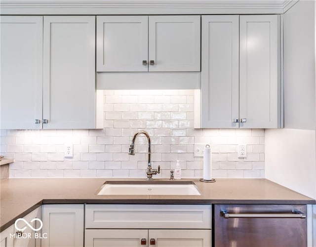 kitchen with sink, stainless steel dishwasher, and backsplash