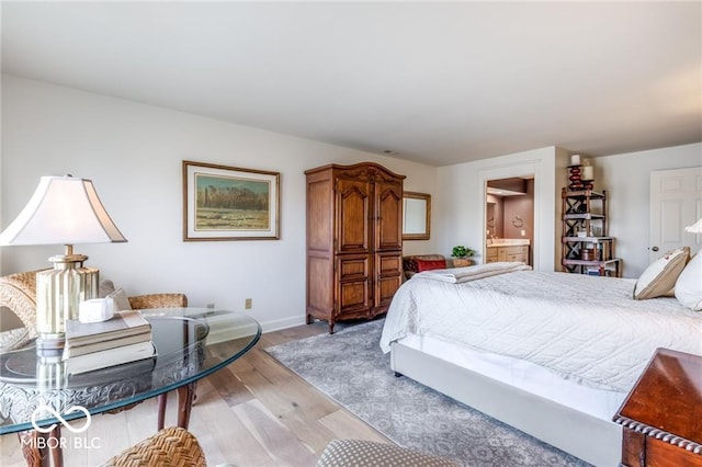 bedroom with ensuite bathroom and light wood-type flooring