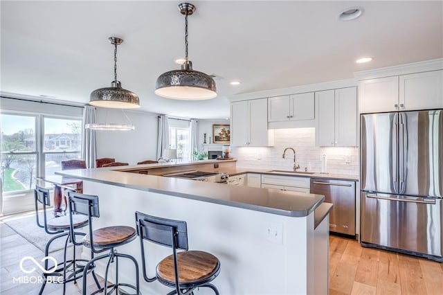 kitchen featuring sink, stainless steel appliances, a kitchen breakfast bar, and white cabinets