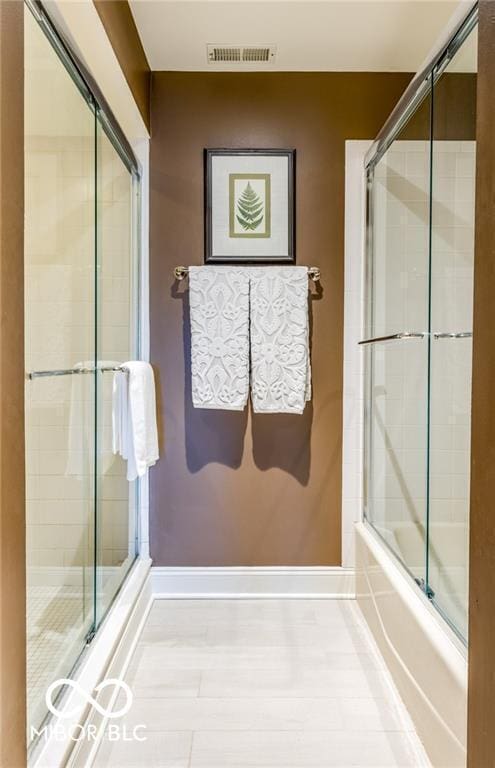 bathroom with combined bath / shower with glass door