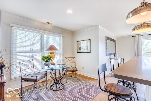 dining area featuring crown molding and light hardwood / wood-style flooring