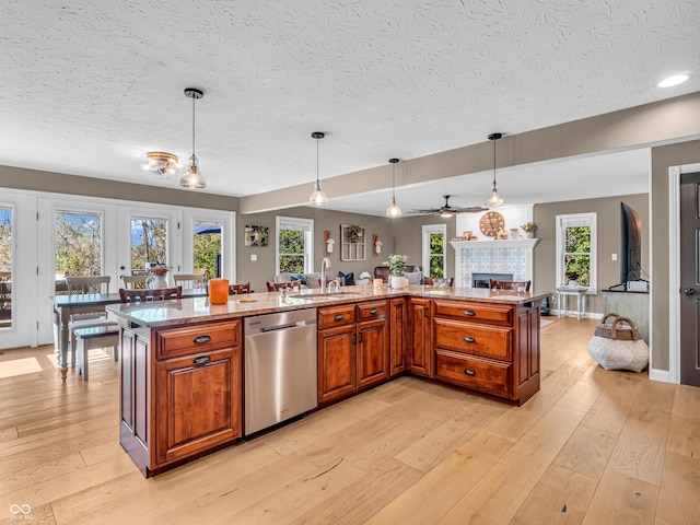 kitchen with decorative light fixtures, stainless steel dishwasher, and a kitchen island