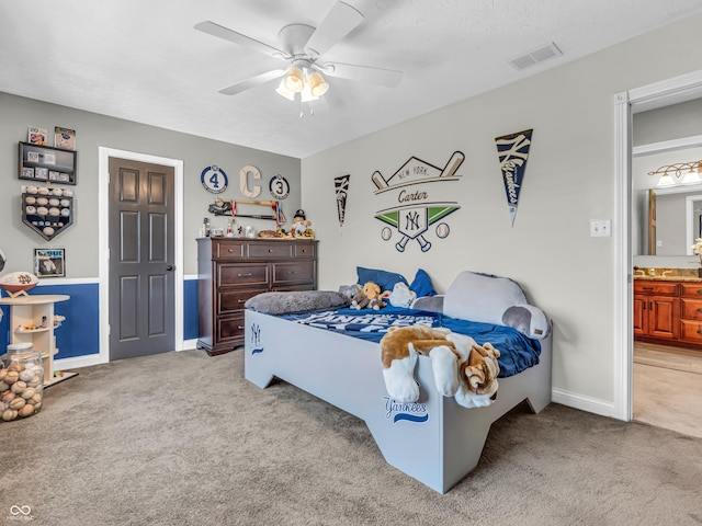 carpeted bedroom featuring ceiling fan and ensuite bathroom