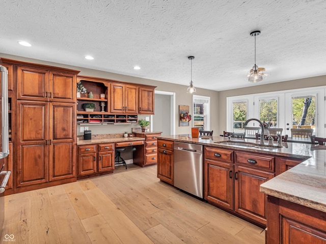 kitchen featuring decorative light fixtures, light hardwood / wood-style floors, stainless steel dishwasher, sink, and a textured ceiling