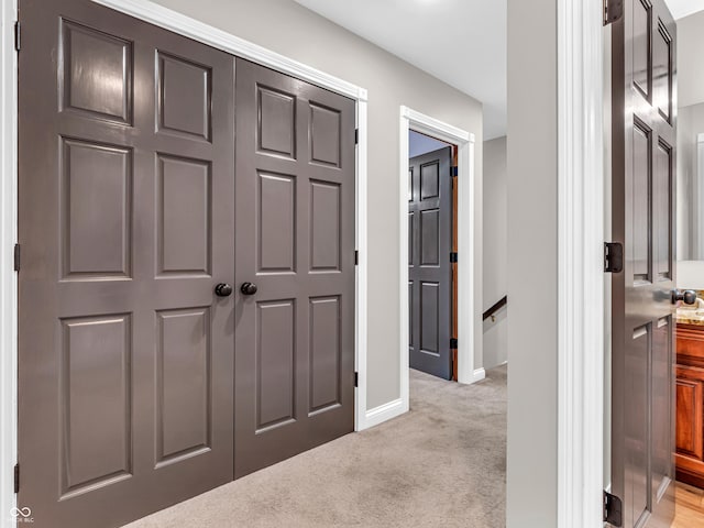 corridor featuring light colored carpet