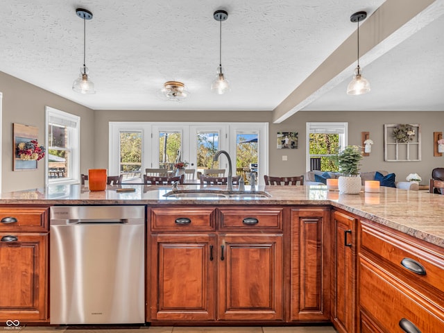 kitchen featuring dishwasher, a textured ceiling, pendant lighting, light stone counters, and sink