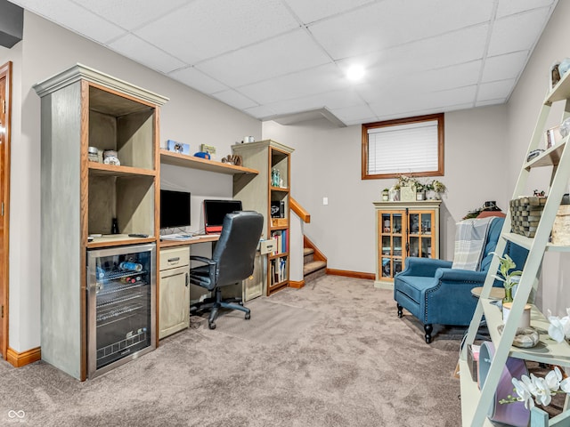 office area featuring carpet, wine cooler, and a drop ceiling