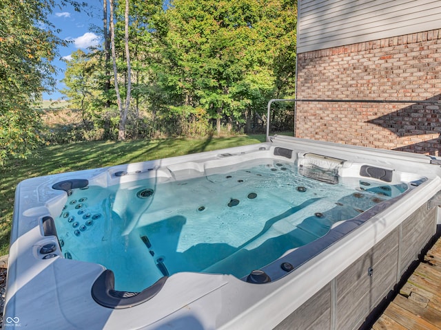 view of swimming pool with a hot tub and a yard