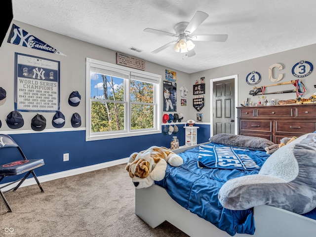 carpeted bedroom featuring a textured ceiling and ceiling fan