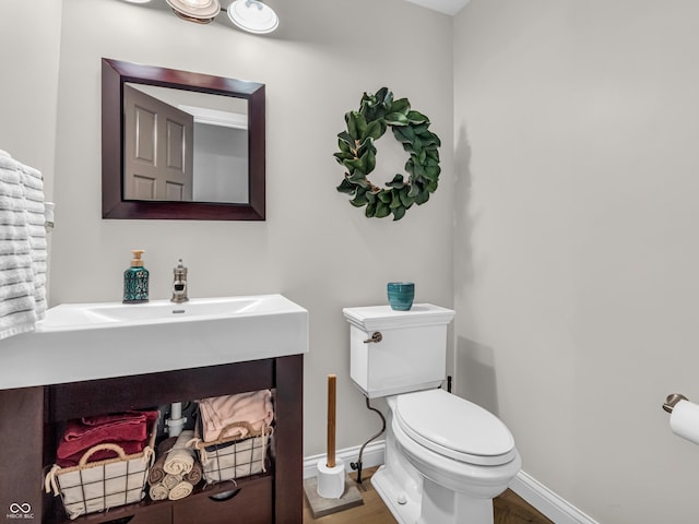 bathroom with toilet and hardwood / wood-style flooring