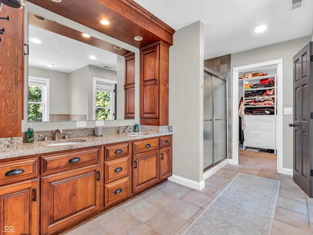 bathroom with tile patterned floors, walk in shower, and vanity