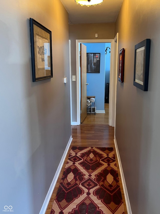 hallway with hardwood / wood-style floors