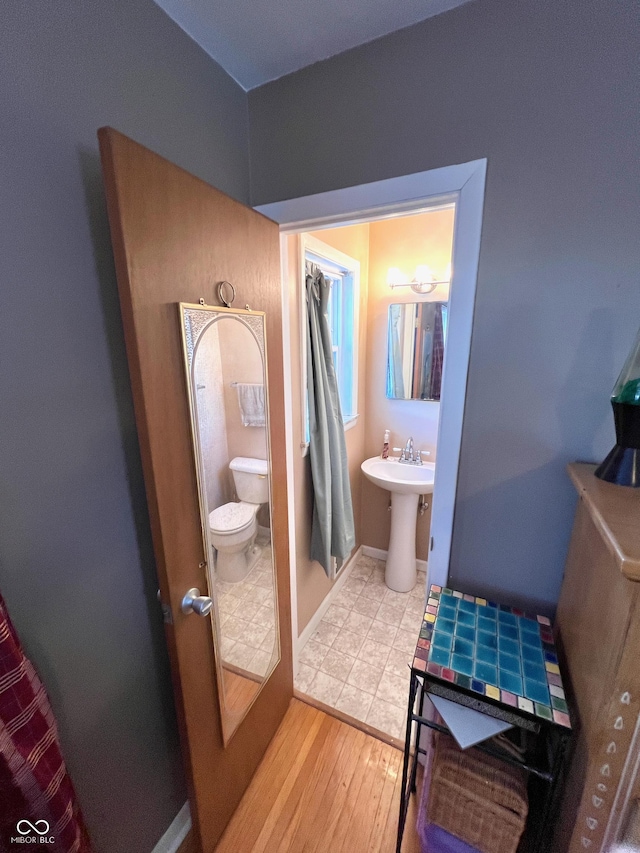 bathroom with sink, toilet, and hardwood / wood-style floors