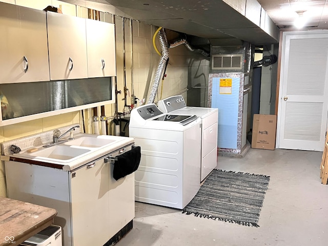 washroom featuring cabinets, washing machine and dryer, and sink