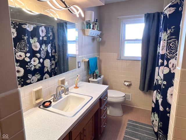 bathroom with vanity, tile walls, tile patterned floors, and toilet