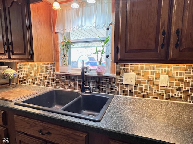 kitchen featuring dark brown cabinets, sink, and decorative backsplash