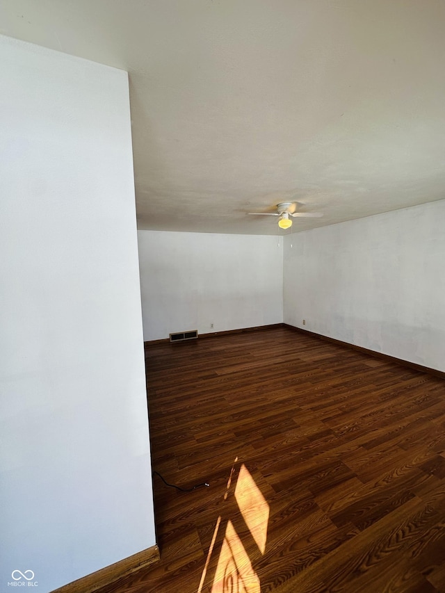 unfurnished room featuring ceiling fan and dark hardwood / wood-style flooring