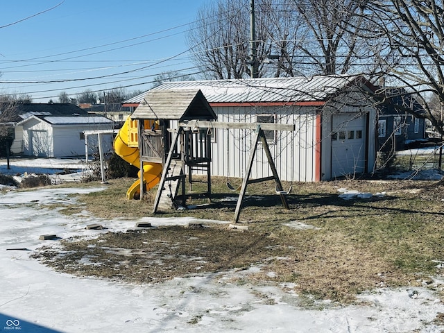 snow covered structure featuring a playground