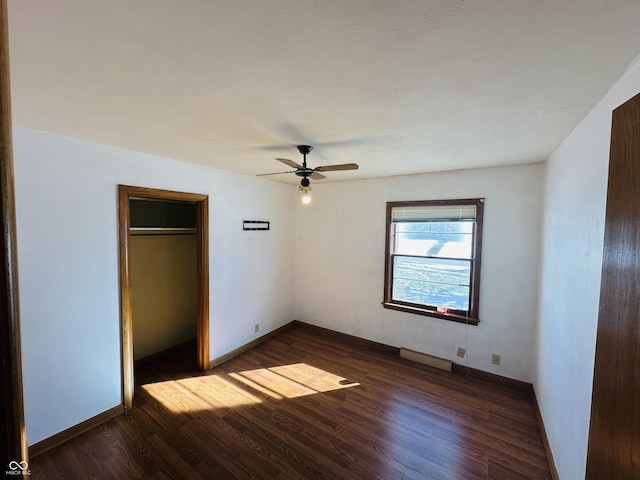 unfurnished bedroom featuring ceiling fan, a closet, and dark wood-type flooring